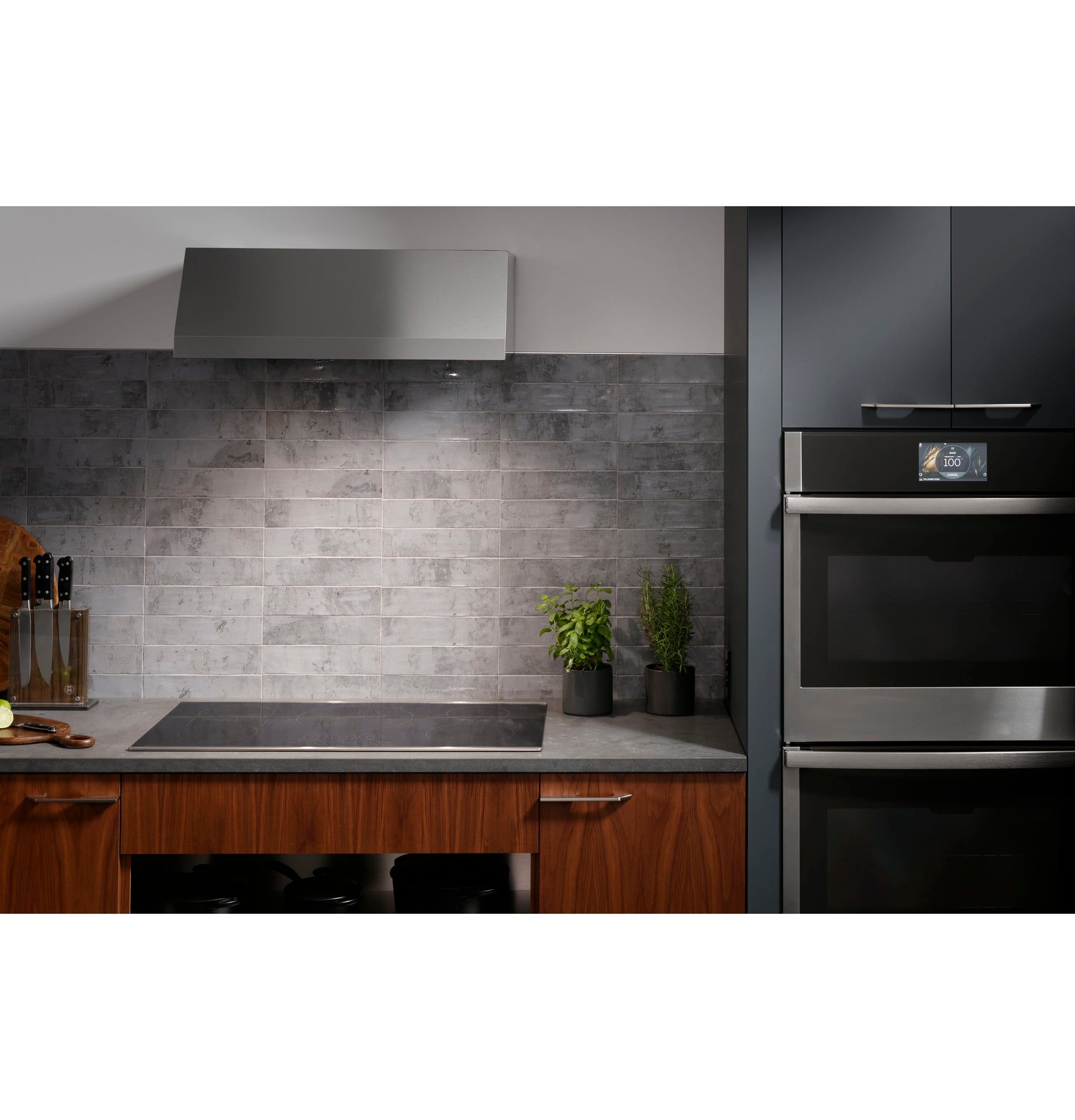 Built-in induction cooktop with sleek touch controls set in modern kitchen featuring wood base cabinets and gray tile backsplash