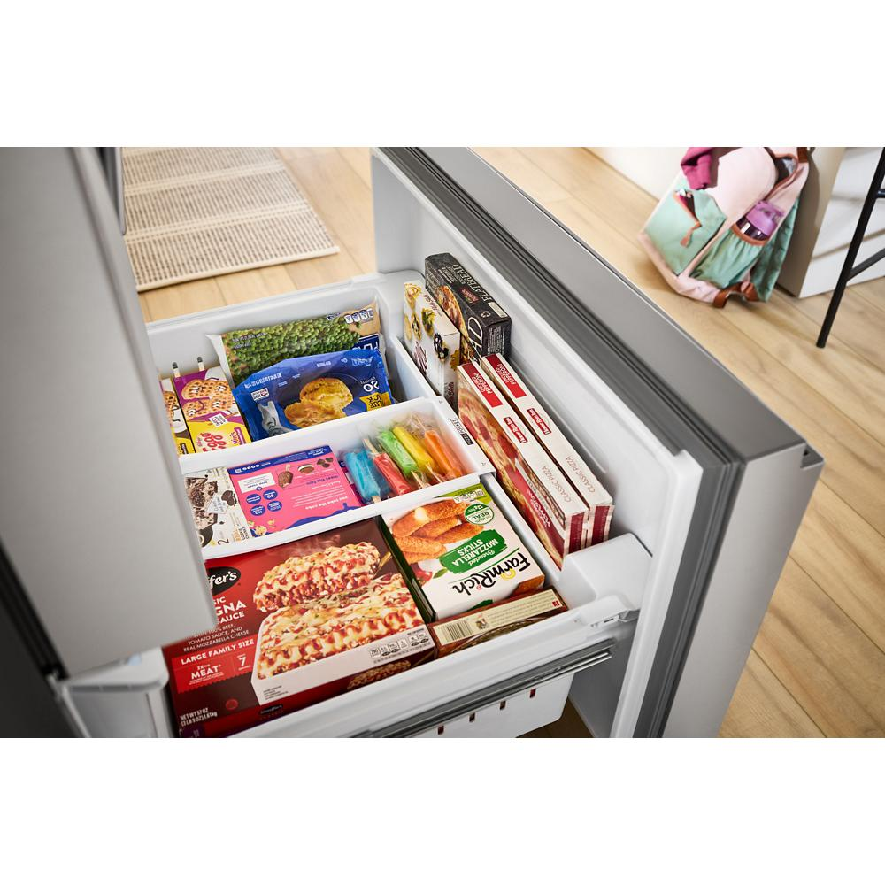 Open flexible temperature drawer in stainless steel French door refrigerator filled with frozen meals and snacks