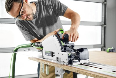 Man using Festool plunge cut track saw on guide rail for precise splinter-free cuts in home improvement power tools collection