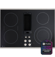 Black glass electric cooktop with integrated downdraft vent and stainless steel control knobs in kitchen appliances collection