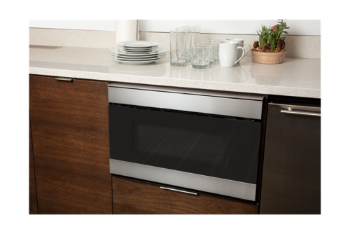 Built-in stainless steel microwave drawer with flat panel design integrated into modern kitchen cabinetry