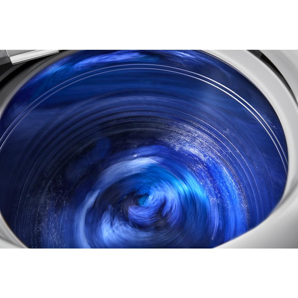 Inside view of a top load washer spinning vibrant blue water in washers and dryers appliance category