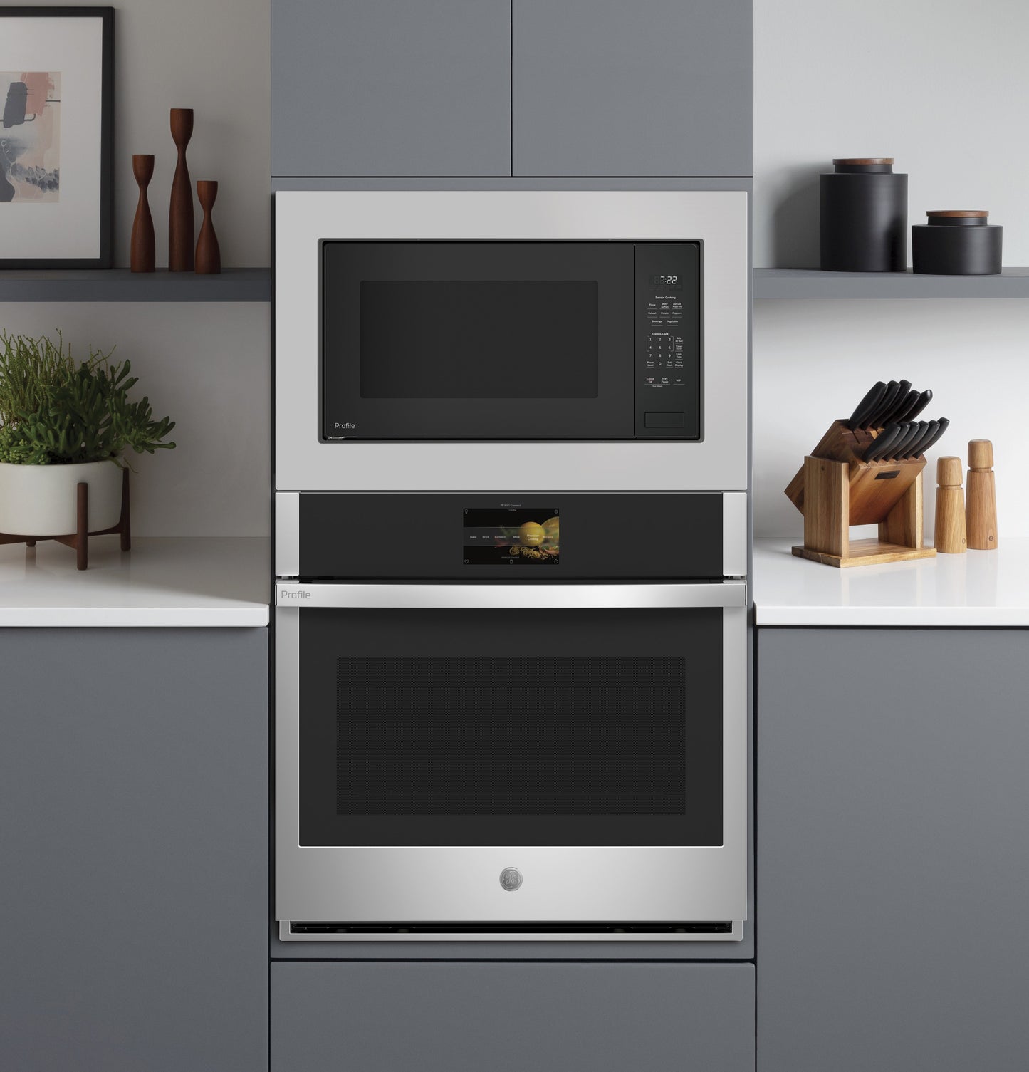 Built-in stainless steel microwave with digital controls above a matching wall oven in modern kitchen setting