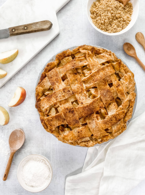 Baked lattice apple pie in a 9-inch USA PAN pie pan with cinnamon sugar topping on a light surface