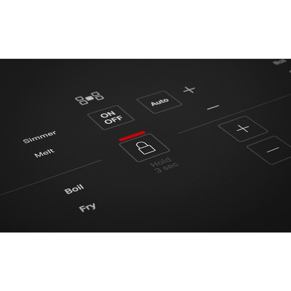 Close-up of black induction cooktop touch controls featuring lock, power, and cooking mode buttons from KitchenAid cooktops collection