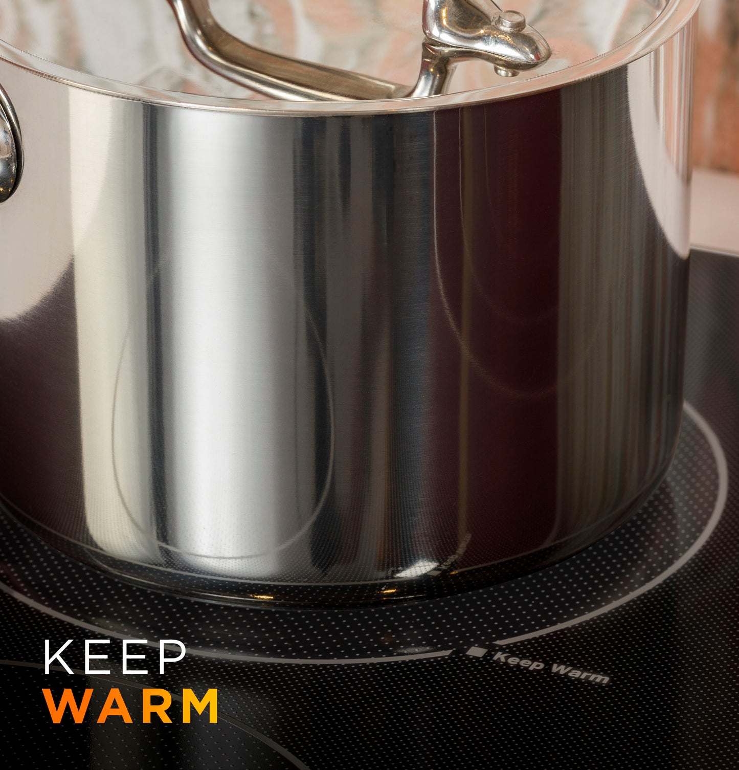Close-up of stainless steel pot on an active burner of a built-in knob control electric cooktop from kitchen appliances.