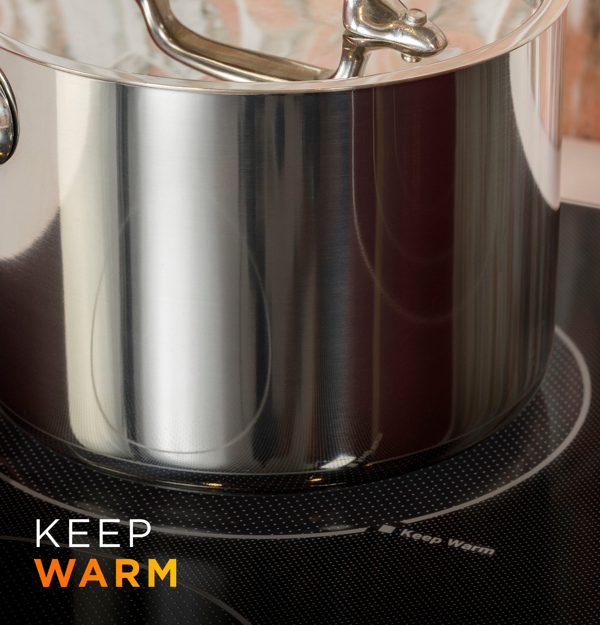 Close-up of stainless steel pot on an active burner of a built-in knob control electric cooktop from kitchen appliances.