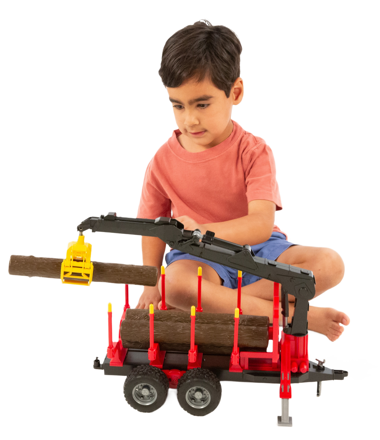 Child playing with red and black Bruder toy forestry trailer with crane and logs in Vehicles & Remote Controlled Toys collection