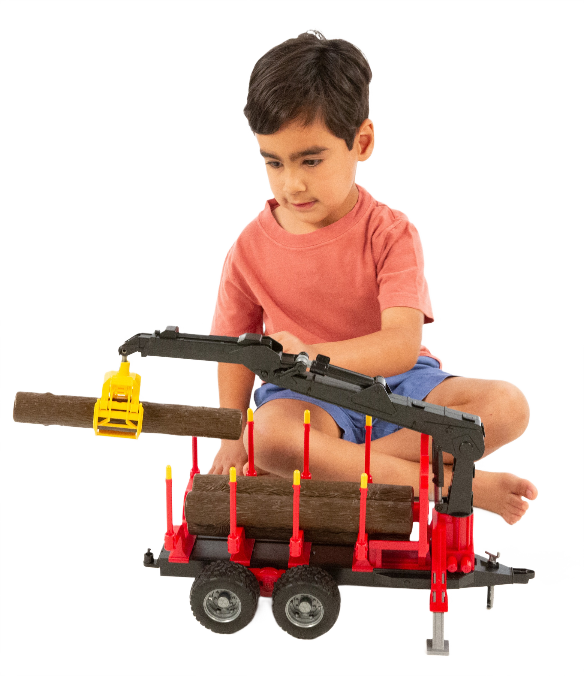Child playing with red and black Bruder toy forestry trailer with crane and logs in Vehicles & Remote Controlled Toys collection