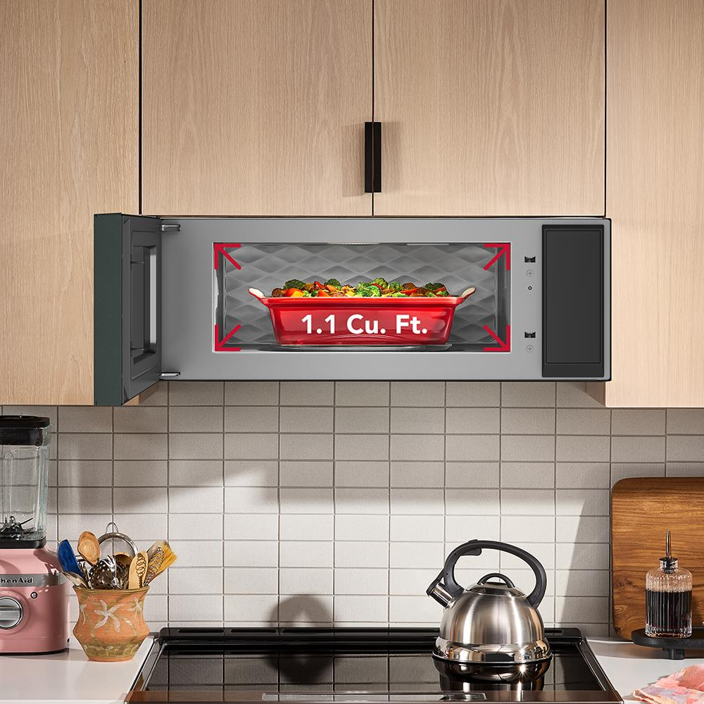Open view of a microwave with 1.1 cubic feet capacity and KitchenAid branding in a modern kitchen setting