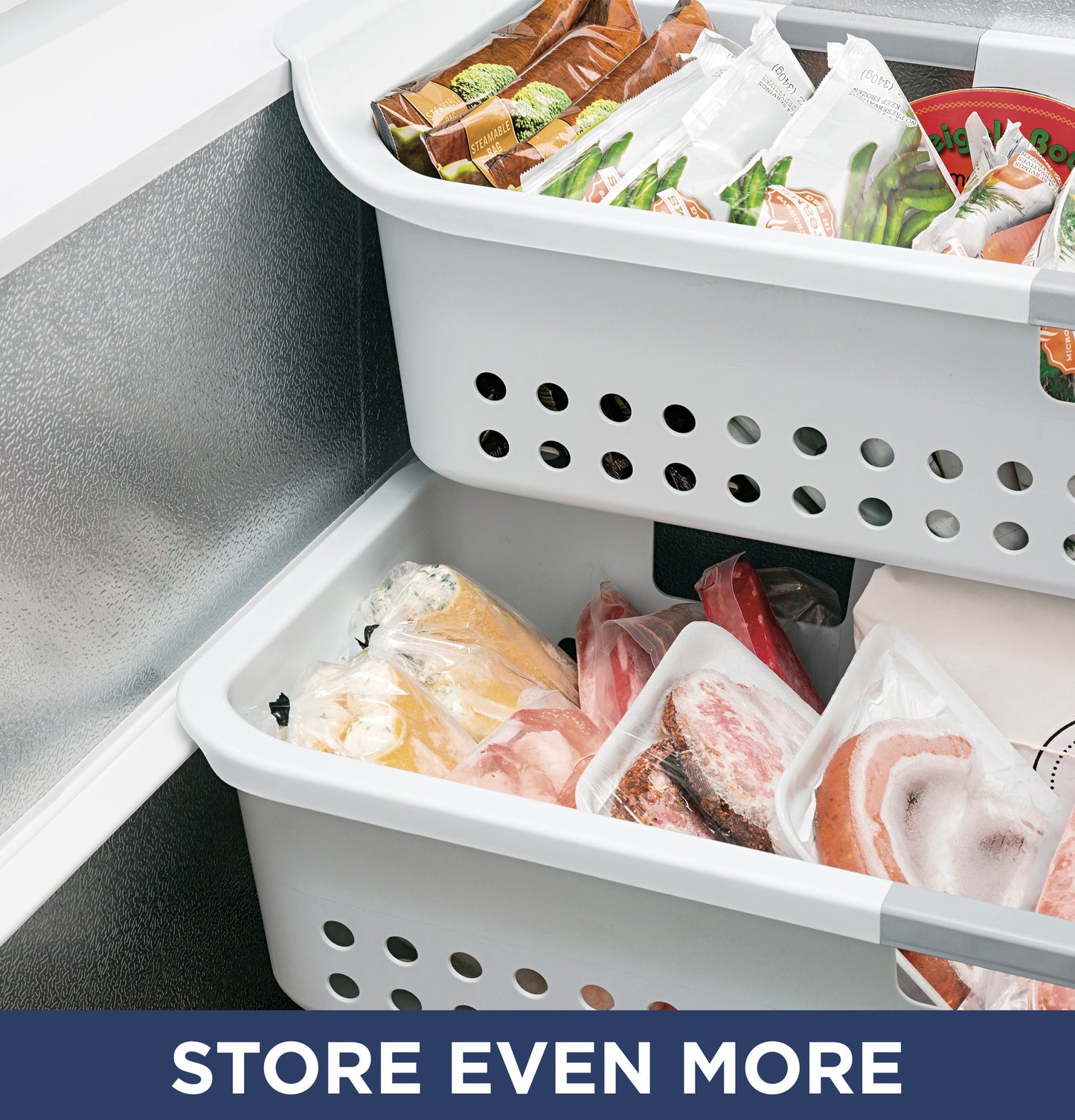Two white storage baskets filled with frozen meats and packaged foods inside a manual defrost chest freezer