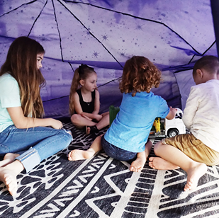 Children playing inside a glowing starry night inflatable tent for imaginative indoor activities and fun playtime