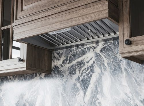 stainless steel range hood insert with baffle filters installed under wood cabinetry for kitchen ventilation and home improvement