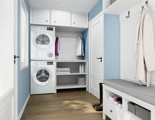 Stacked white compact front load washer and dryer in light blue laundry room with open shelving and bench seating