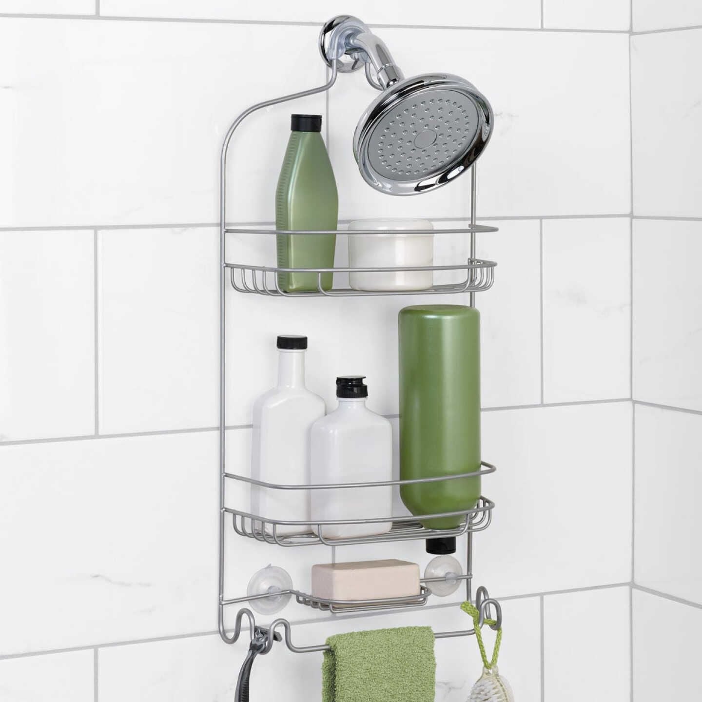 Chrome shower caddy mounted on white tile wall holding toiletries and hanging towel for home improvement use