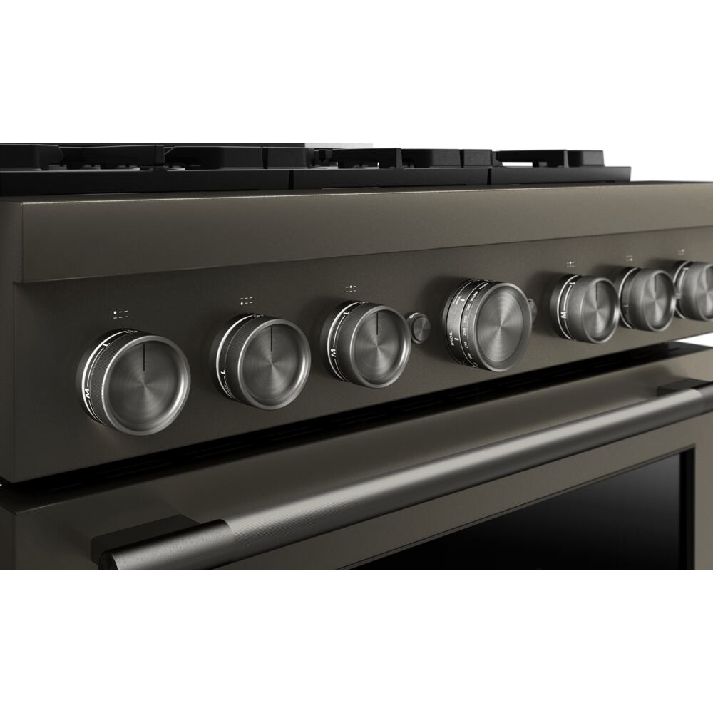 Close-up of a commercial-style gas range control panel with stainless steel knobs in KitchenAid kitchenware collection