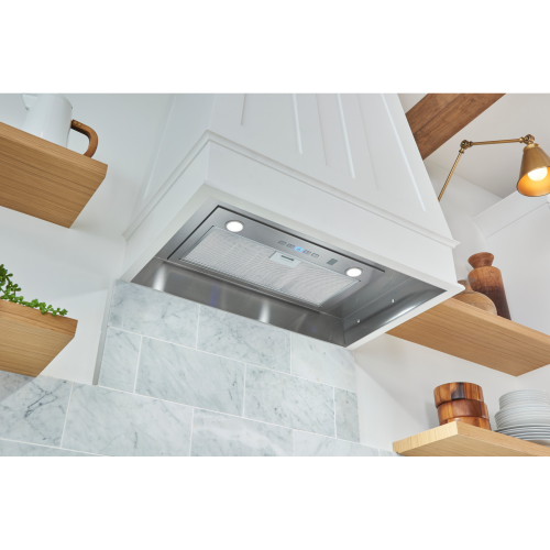 Under-cabinet stainless steel range hood insert with LED lights and voice control in modern kitchen setting