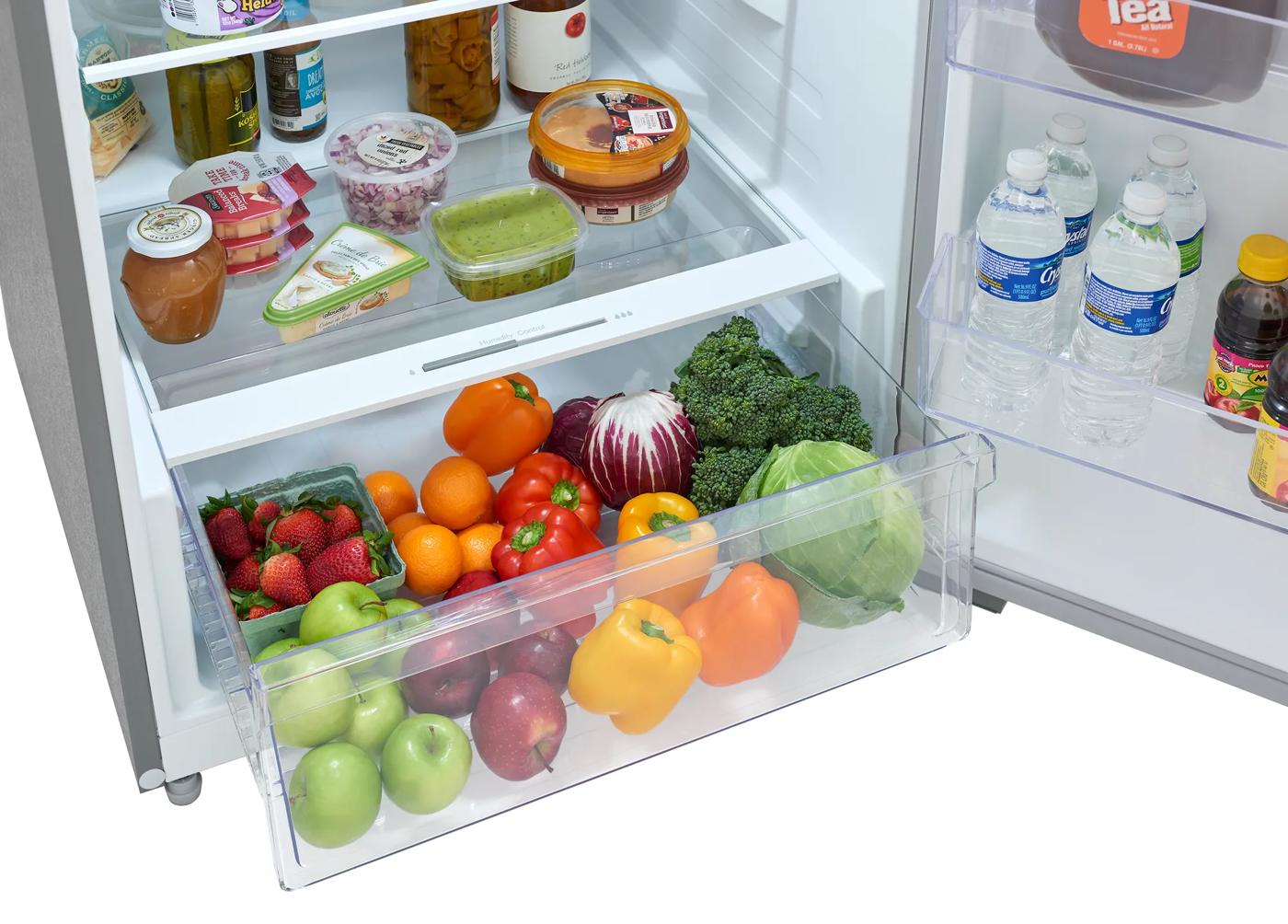 Bottom drawer of refrigerator filled with fresh fruits and vegetables in kitchen appliances collection