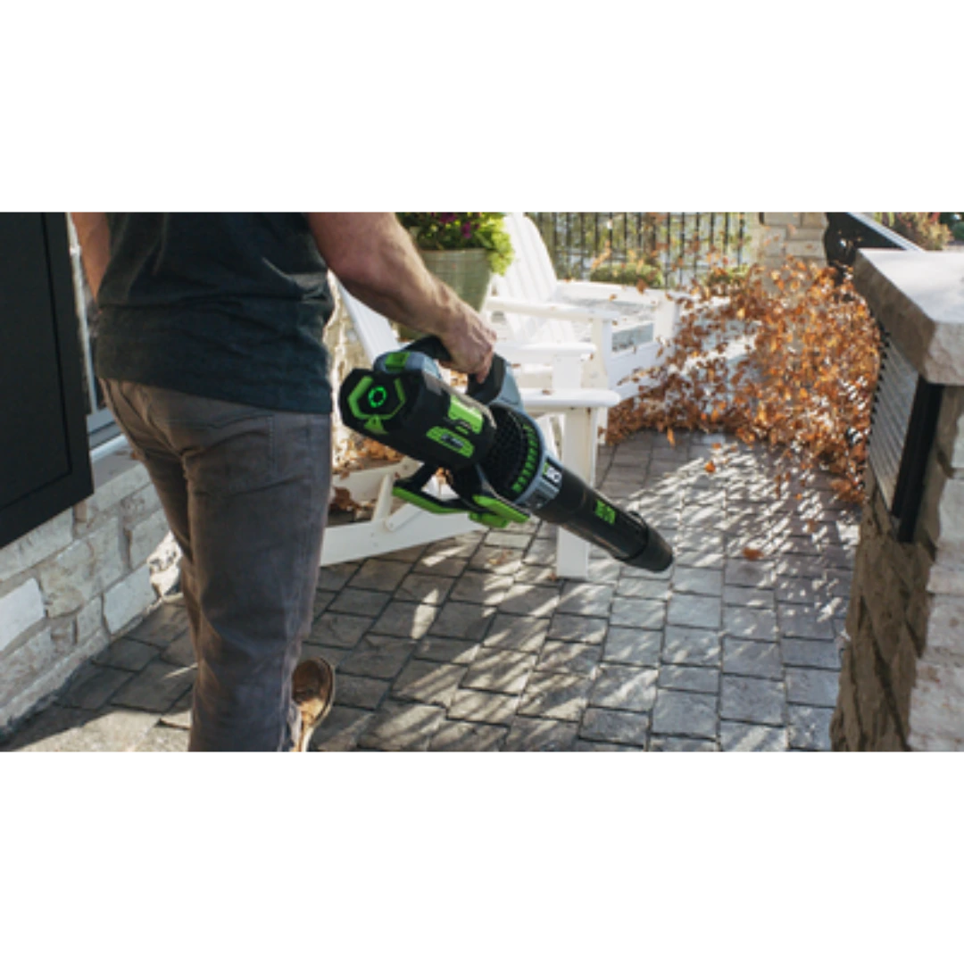 Person using EGO Power+ 765 CFM cordless blower on outdoor patio for home improvement in Power Tools collection