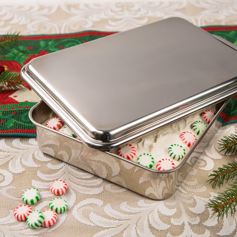 Rectangular stainless steel cake pan with lid slightly ajar revealing red and green peppermint candies in kitchenware collection