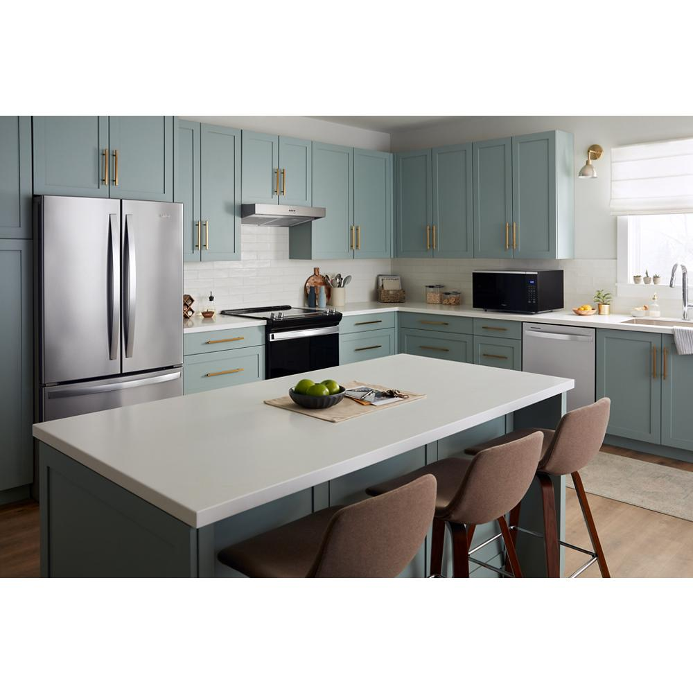 Modern kitchen with blue cabinetry featuring a black sensor cooking microwave on white countertop near stainless steel appliances