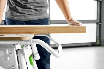 Person securing wood plank on a white Festool woodworking worktable from the tool stands collection