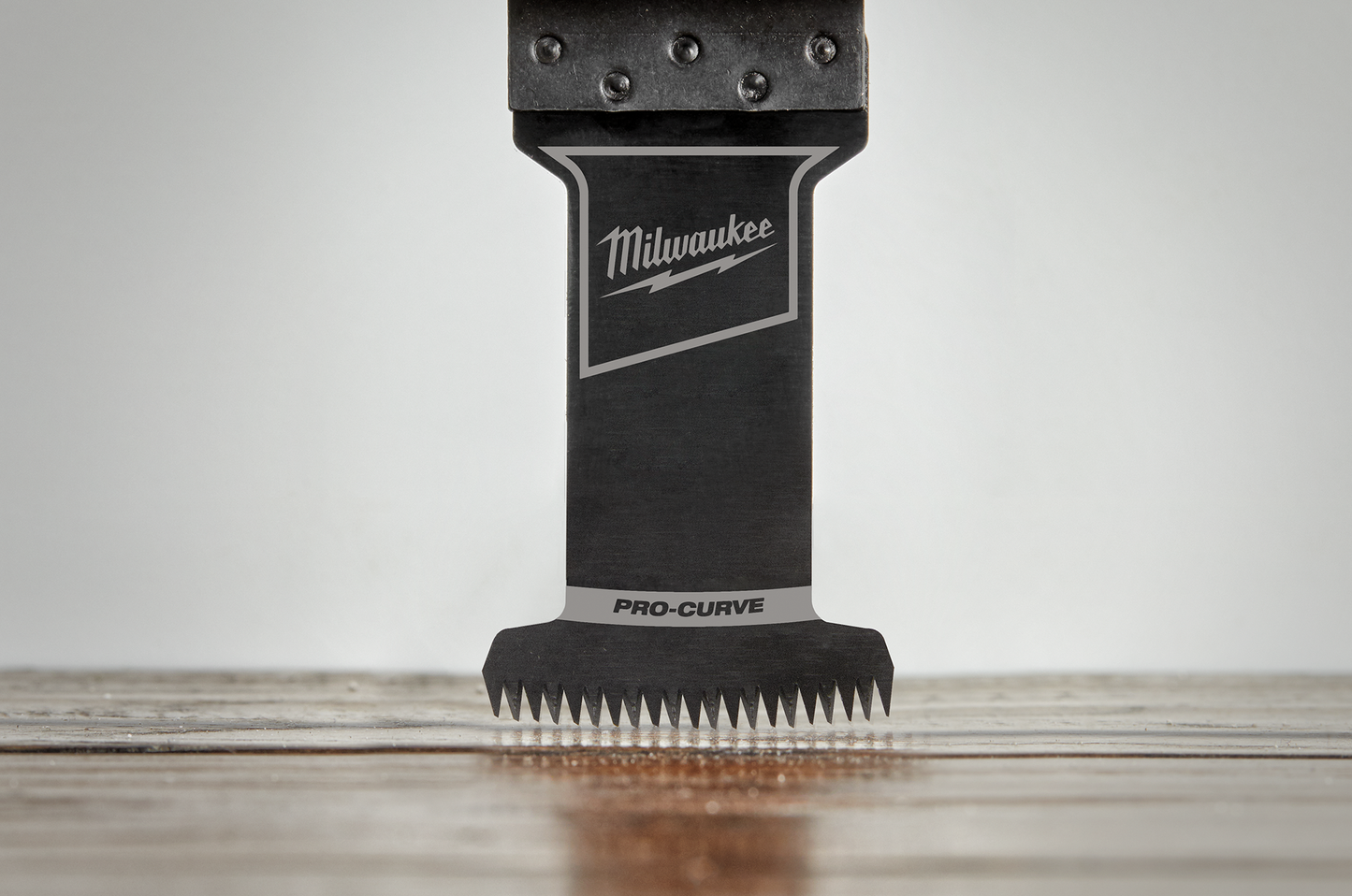 Black Milwaukee PRO-CURVE multi-tool blade with precision teeth for detailed home improvement tasks