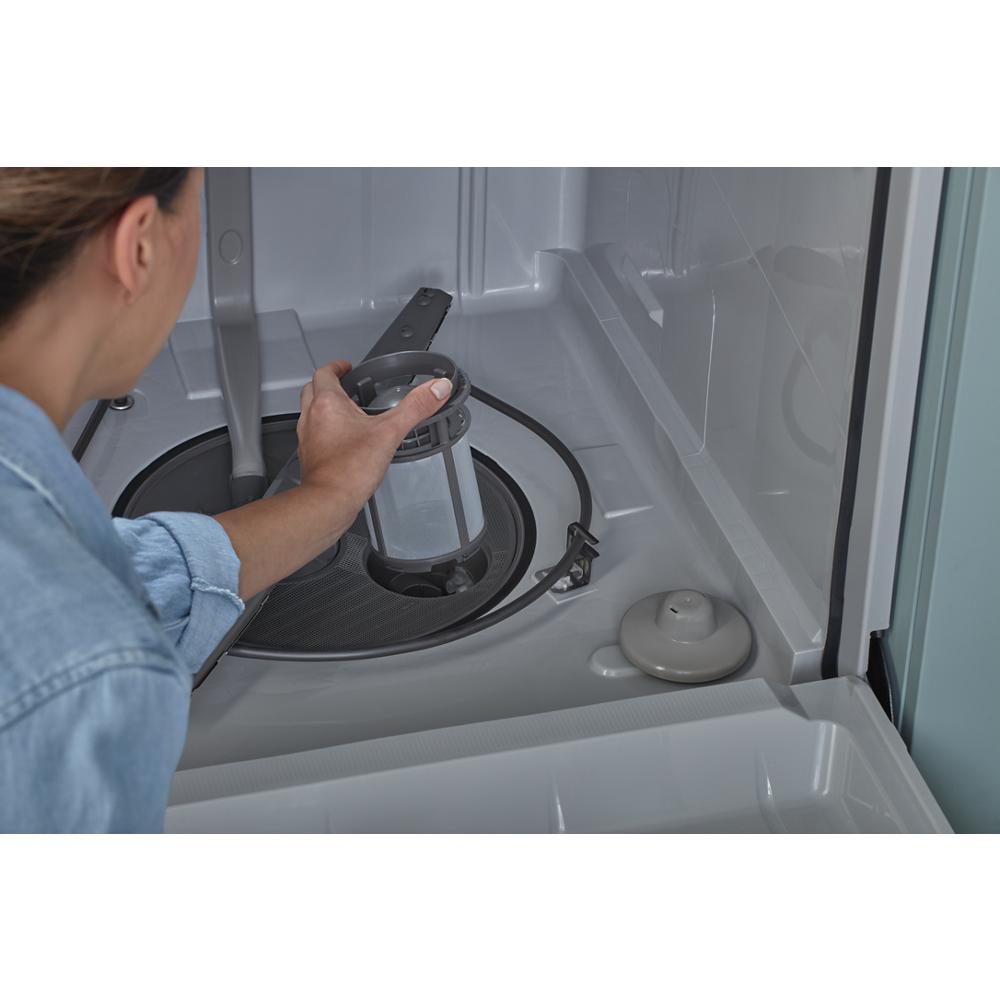 Person removing filter from interior base of ENERGY STAR® certified quiet dishwasher in kitchen appliance setting