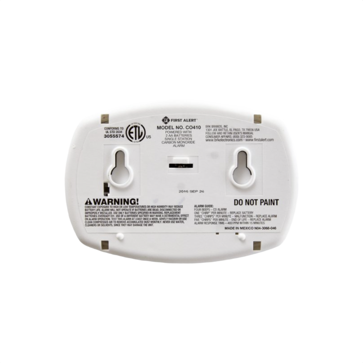Back view of white First Alert carbon monoxide detector with mounting slots for electrical and fire safety installation