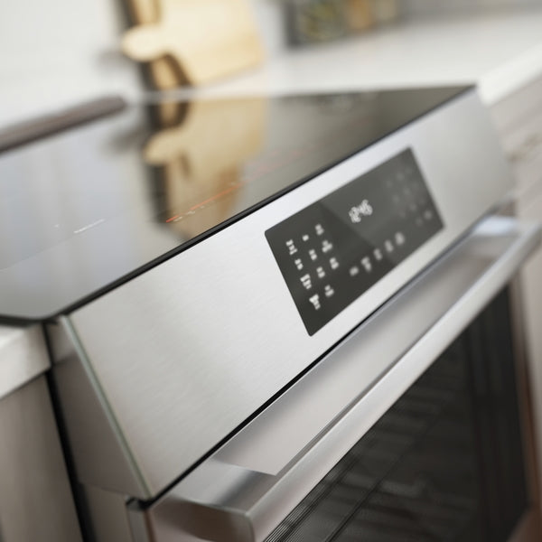 close-up of stainless steel induction slide-in range control panel in modern kitchen setting
