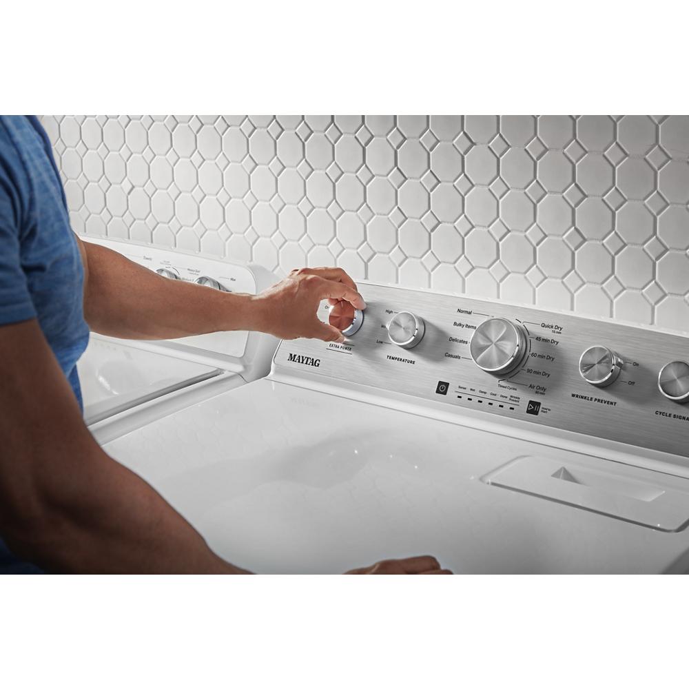 Hand adjusting control knob on silver panel of white top load gas dryer in Dryers and Appliances collection