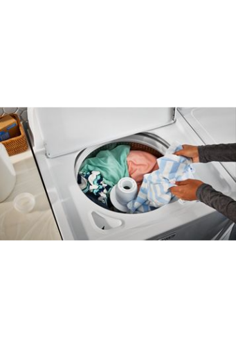 Hands loading a white top load washer with colorful clothes in a laundry room from Washers & Dryers collection