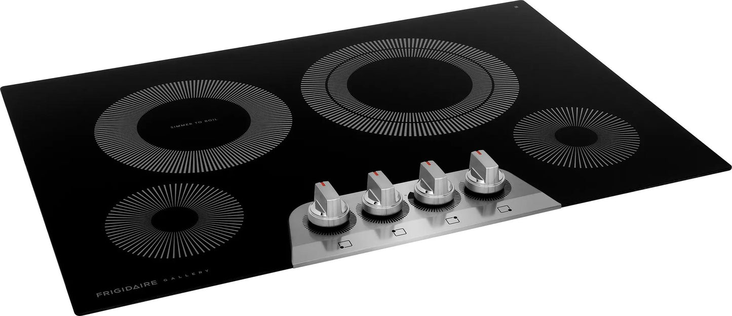Black electric cooktop with four radiant heating elements and silver control knobs in kitchen appliance setting
