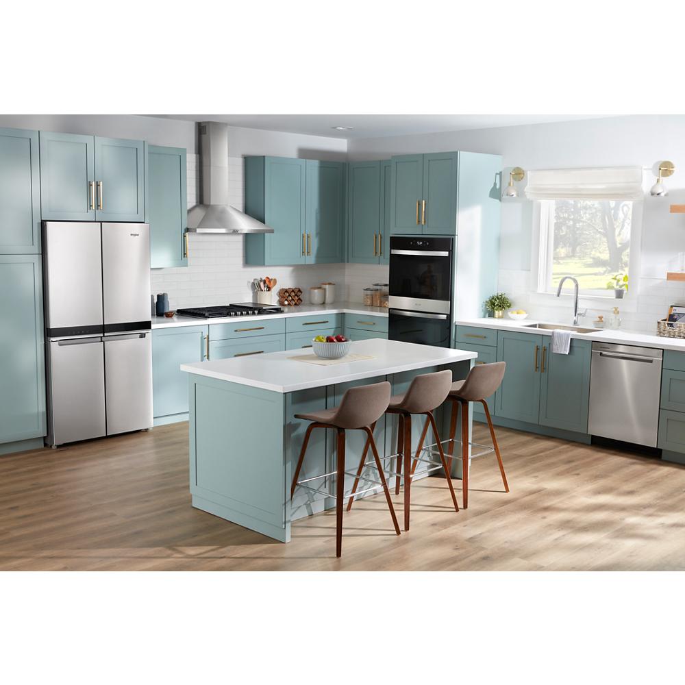 Bright modern kitchen with light blue cabinetry, stainless steel appliances, and a curved glass wall mount range hood