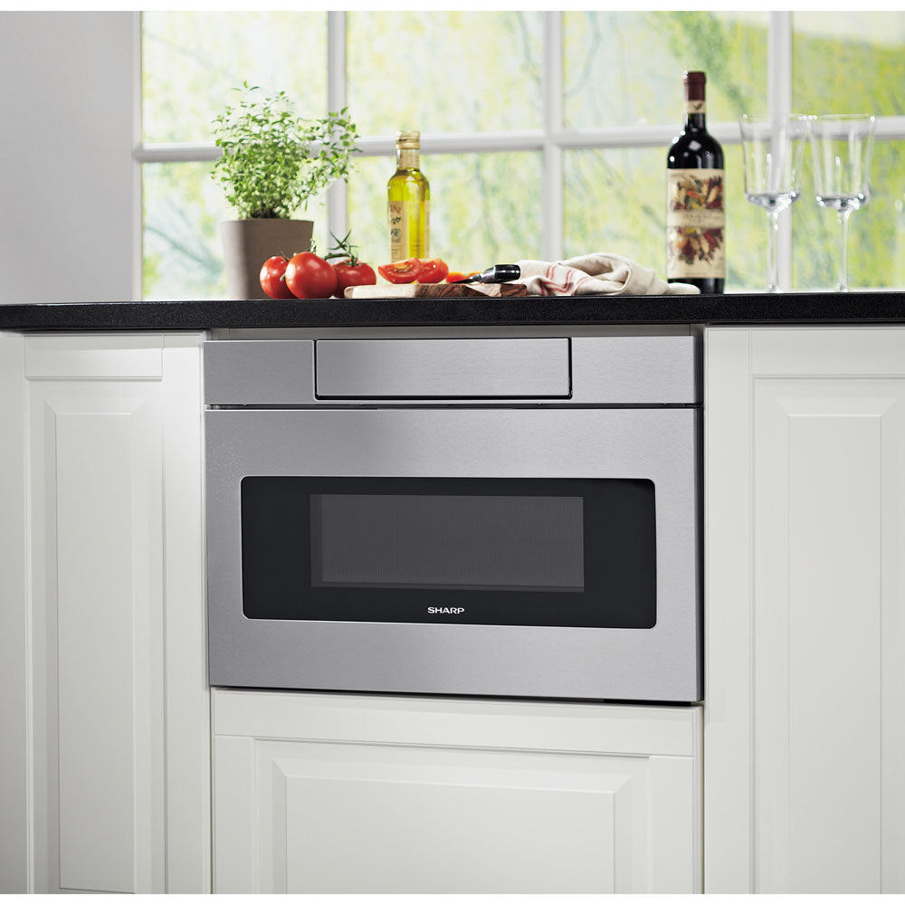 Built-in stainless steel microwave drawer integrated into white cabinetry with kitchen counter accessories nearby