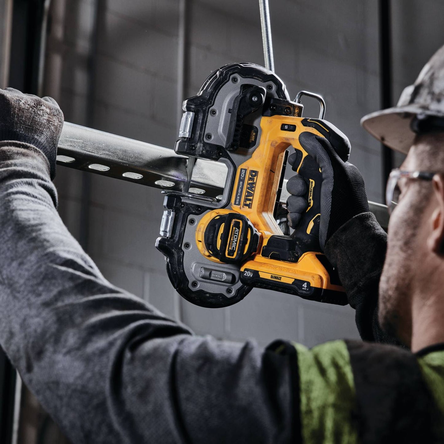 Yellow and black cordless compact band saw cutting metal pipe for home improvement and battery powered power tools collection