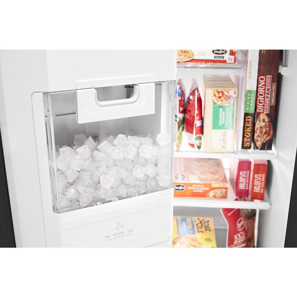 Clear indoor ice bin filled with ice cubes inside a white side-by-side refrigerator in kitchen appliances collection