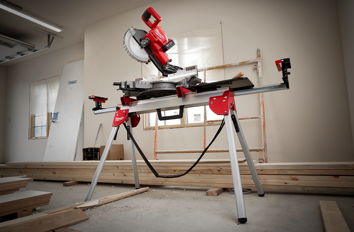 Portable red and silver miter saw mounted on foldable stand with steel legs for woodworking and home improvement.