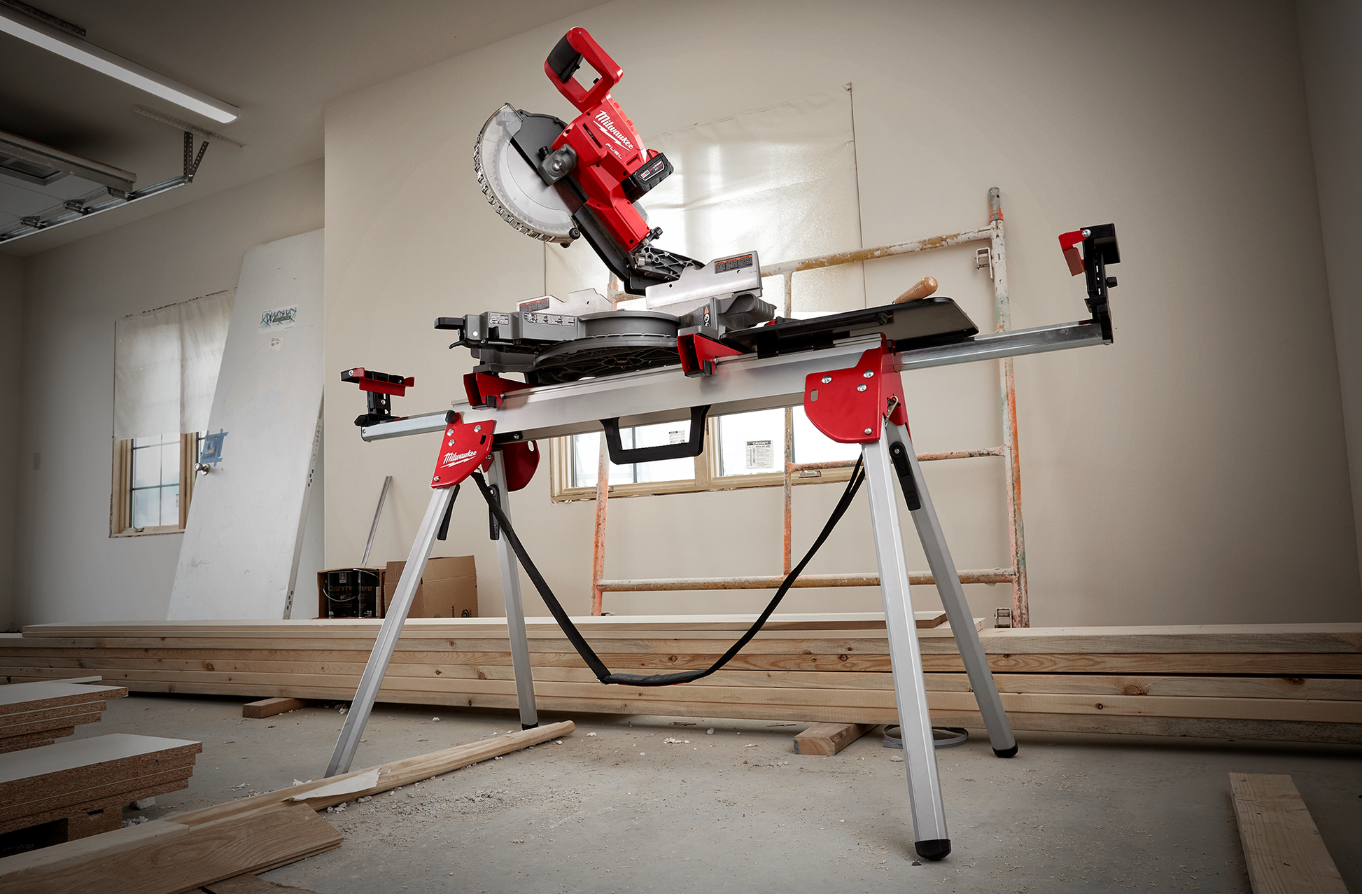 Portable red and silver miter saw mounted on foldable stand with steel legs for woodworking and home improvement.