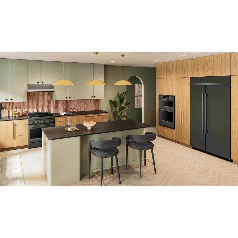 Contemporary kitchen with black ore wall oven and refrigerator, green cabinets, wooden accents, and black island countertop