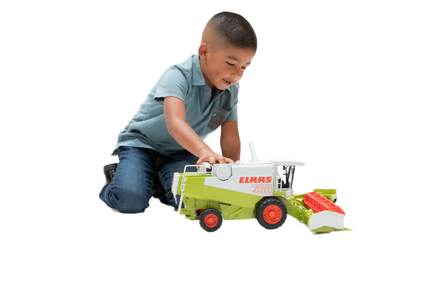 Young boy playing with detailed green and white Bruder Claas Lexion 480 Combine toy with red wheels and header attachment
