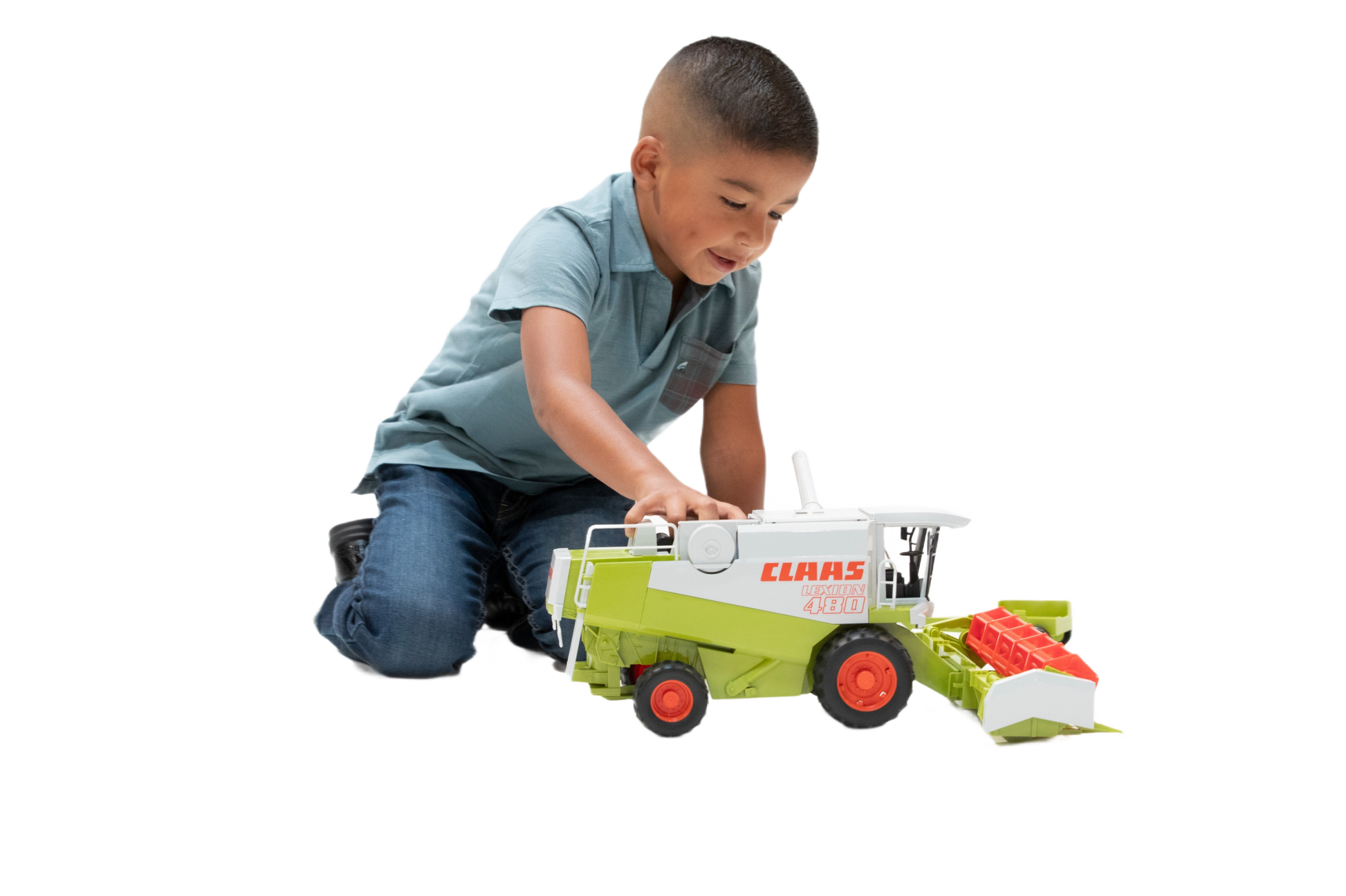 Young boy playing with detailed green and white Bruder Claas Lexion 480 Combine toy with red wheels and header attachment