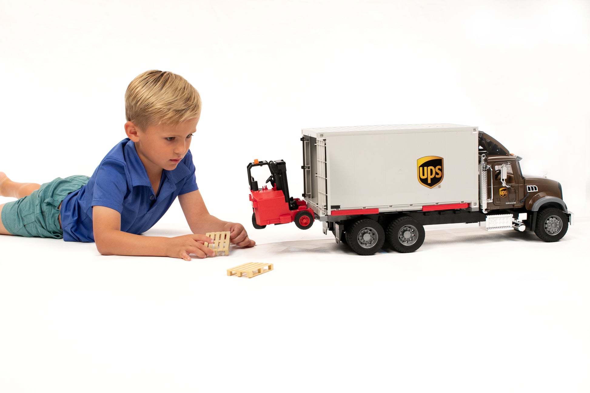 Child playing with brown and beige UPS logistics truck toy and red forklift in Vehicles & Remote Controlled Toys collection