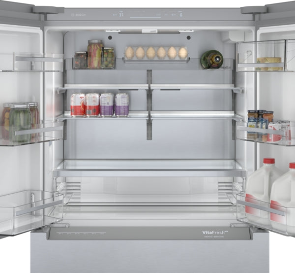 Open stainless steel refrigerator with organized shelves holding beverages, eggs, condiments, and milk in kitchen appliances collection