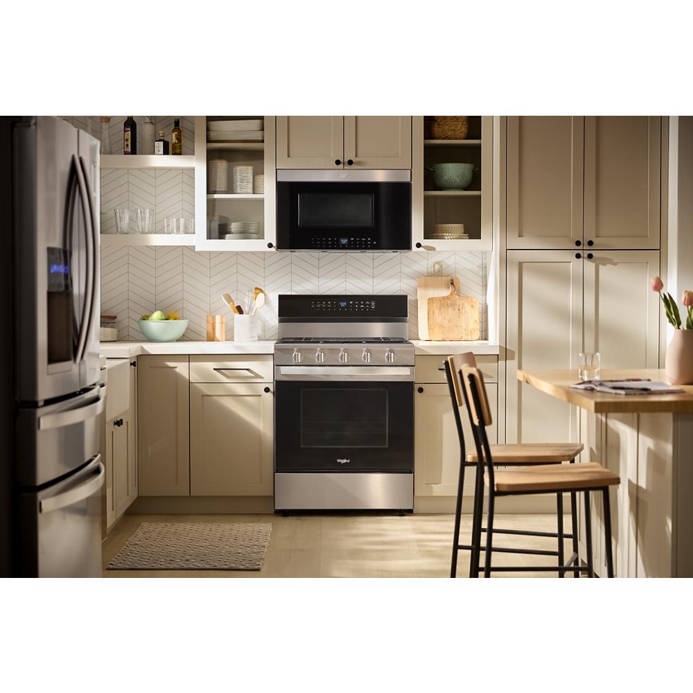 Kitchen with beige cabinetry, stainless steel range, and black built-in air fry microwave from kitchen appliances collection