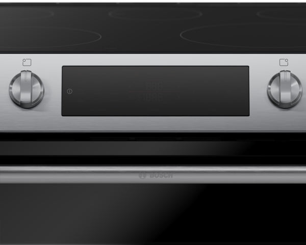 Close-up of stainless steel electric freestanding range control panel with two knobs and digital display in kitchen setting