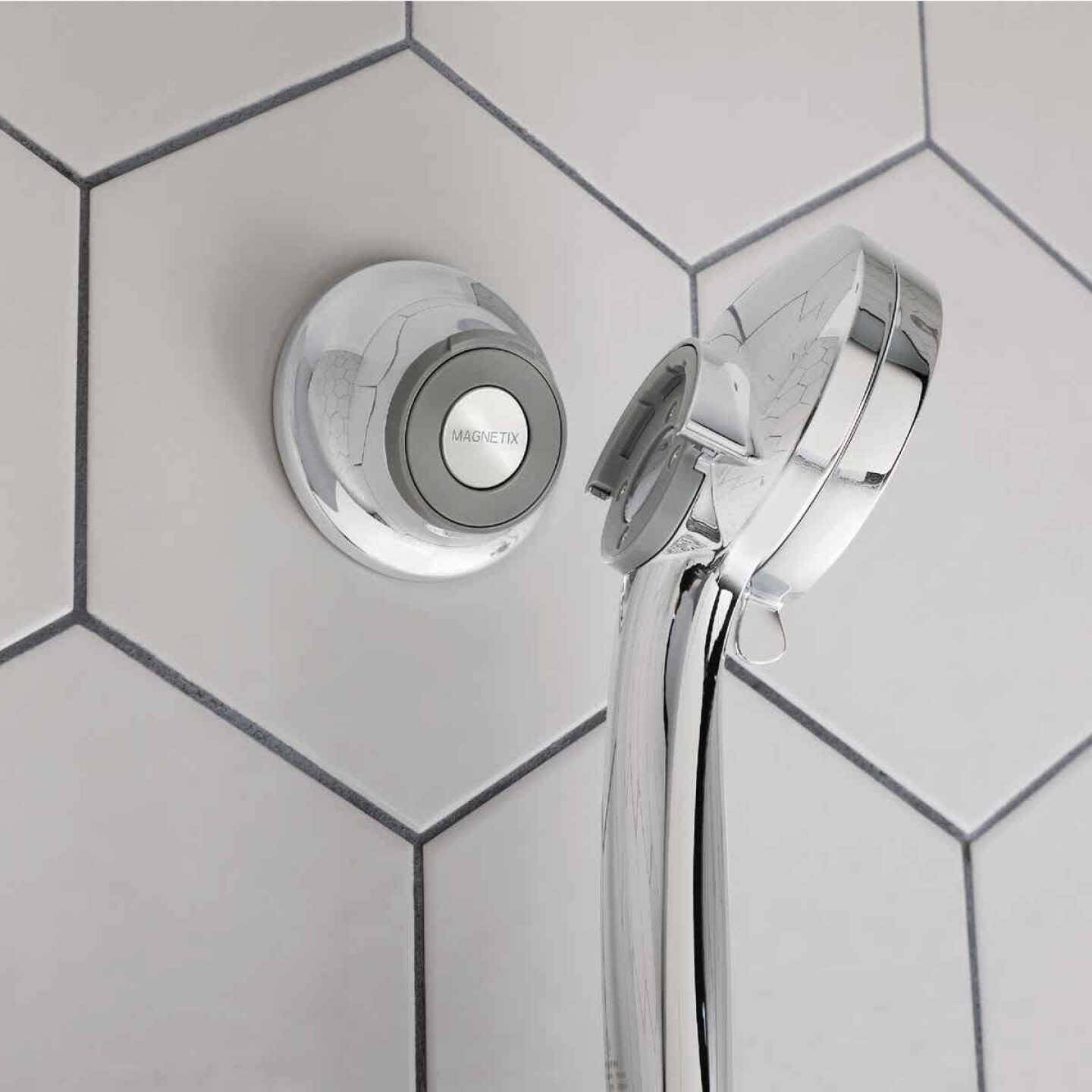 Chrome magnetic remote dock shower bracket mounted on white hexagonal tile wall for home improvement use