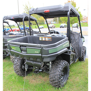Green mid-size utility vehicle with Maxxis Bighorn tires and cargo bed parked on grassy area outdoors