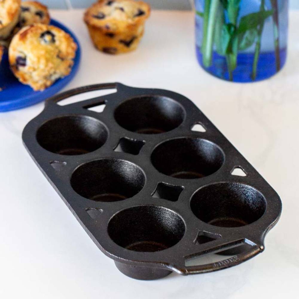 Seasoned black cast iron muffin pan with six cups and dual handles for kitchenware and cooking tools collections