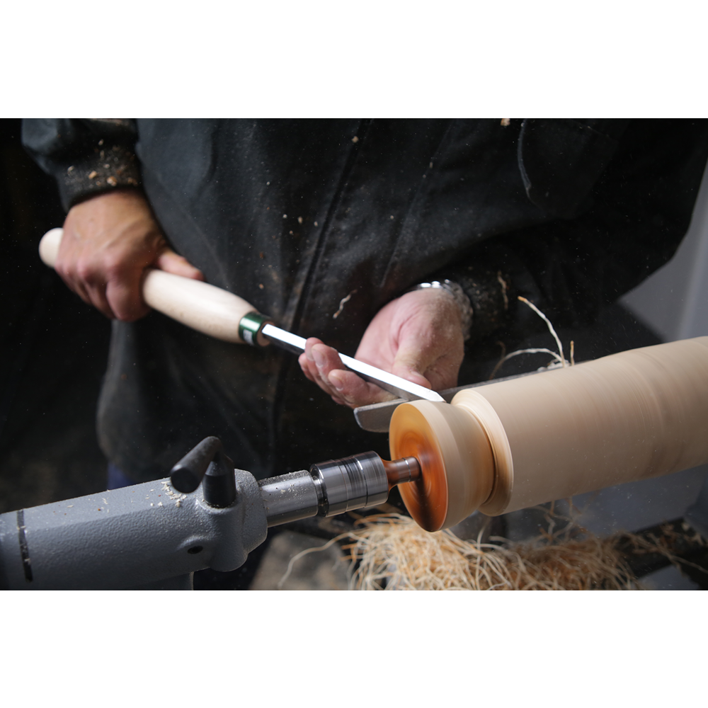 Craftsman shaping wooden workpiece with 1-inch HSS skew chisel from woodworking tools under $100 collection